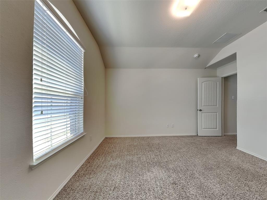 506 Robinson Way Fate, TX 75189 - Photo 15 of 30 Carpeted empty room with vaulted ceiling and baseboards