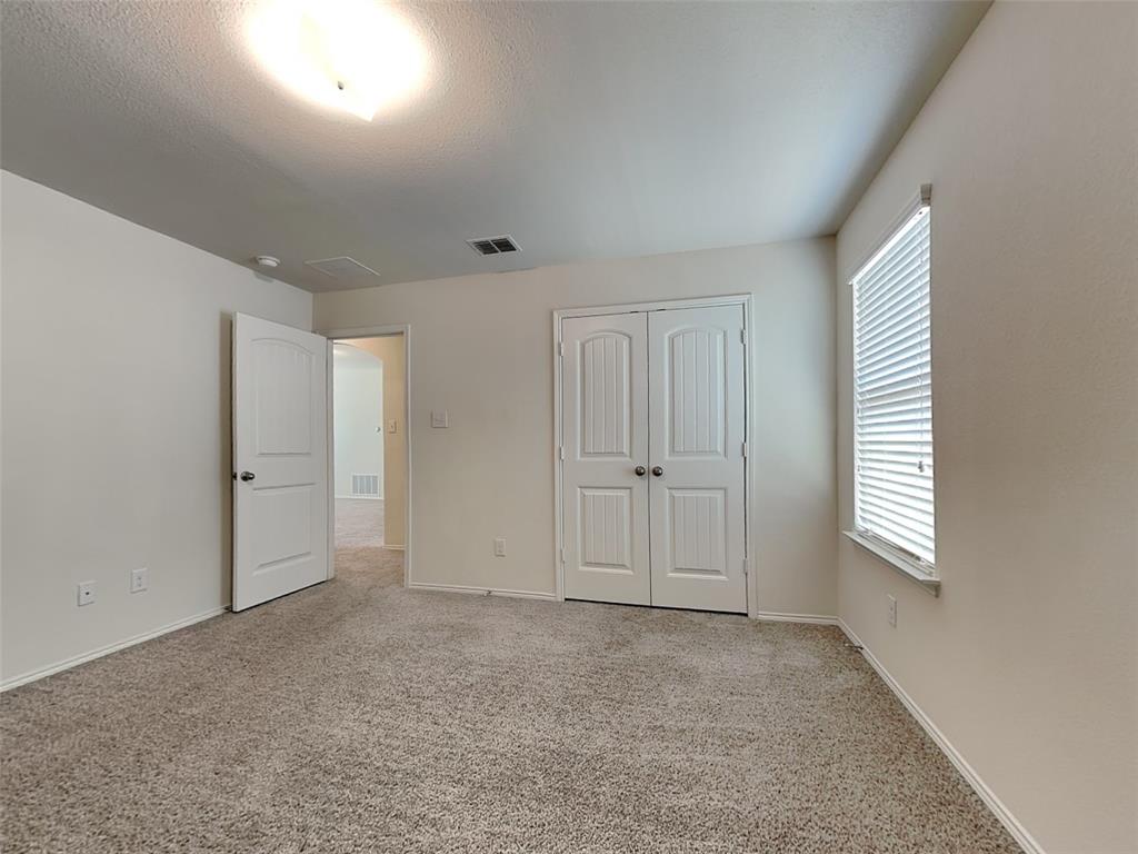 506 Robinson Way Fate, TX 75189 - Photo 19 of 30 Unfurnished bedroom featuring light colored carpet, a closet, and a textured ceiling