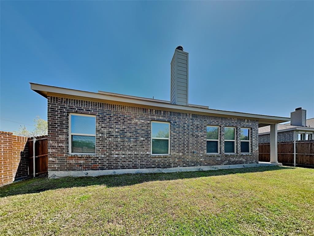 506 Robinson Way Fate, TX 75189 - Photo 28 of 30 Back of property with a fenced backyard, a chimney, and brick siding