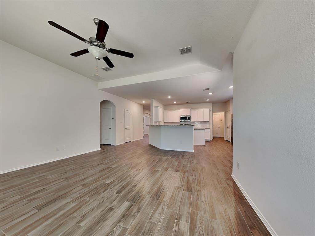 506 Robinson Way Fate, TX 75189 - Photo 3 of 30 Unfurnished living room featuring arched walkways, light wood-style floors, recessed lighting, and ceiling fan