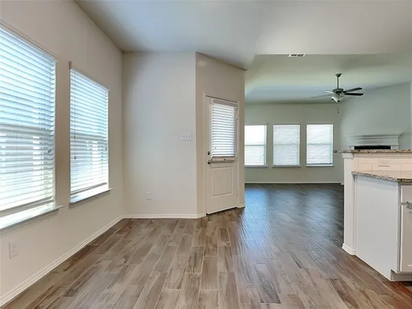 an empty room with wooden floor and windows