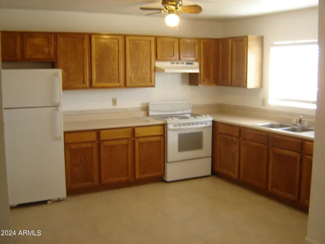 a kitchen with a sink dishwasher stove and white cabinets
