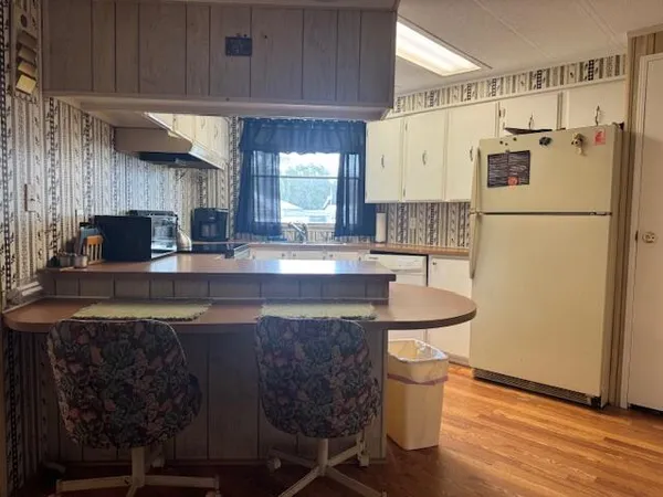 a kitchen with refrigerator and cabinets