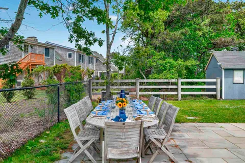 a view of a patio with table and chairs and potted plants