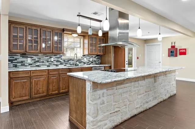a kitchen with granite countertop a sink and cabinets