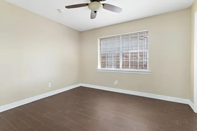 an empty room with a window and a ceiling fan
