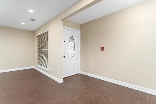 an empty room with wooden floor and white walls