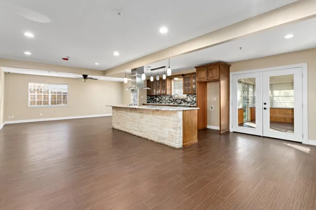 an open kitchen with a refrigerator and a stove top oven