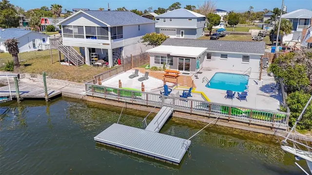 an aerial view of a house with swimming pool lawn chairs and a yard