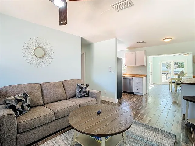 a living room with furniture a chandelier and a flat screen tv