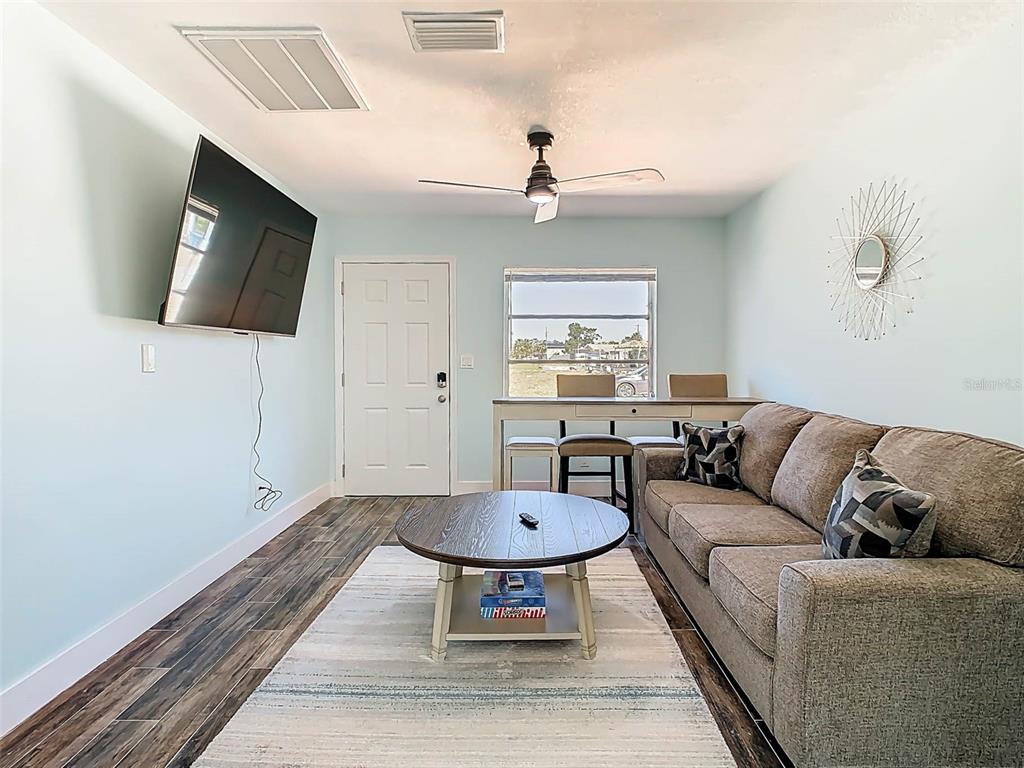 4984 Cedarbrook Lane Hernando Beach, FL 34607 - Photo 14 of 61 a living room with furniture a chandelier and a flat screen tv