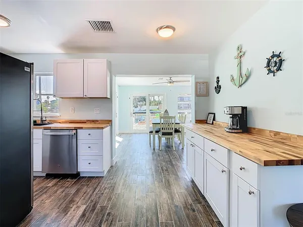a kitchen with granite countertop a stove top oven a sink dishwasher and a refrigerator with wooden floor