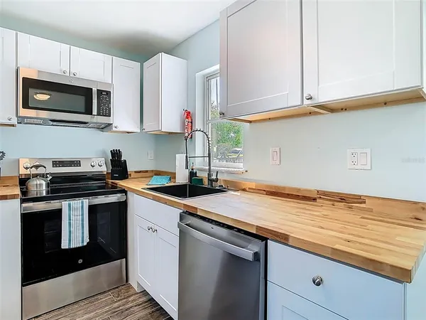 a kitchen with a sink appliances and wooden floor