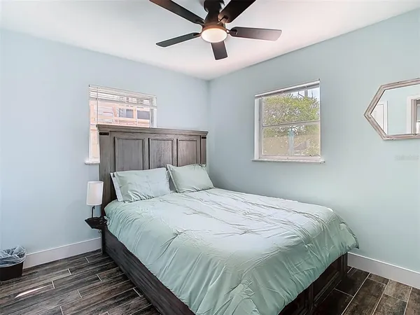 a bedroom with a large bed and a chandelier fan