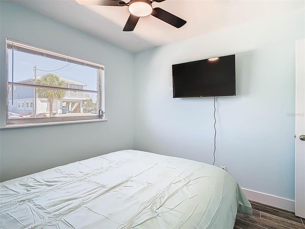 4984 Cedarbrook Lane Hernando Beach, FL 34607 - Photo 32 of 61 a bedroom with a bed and a flat screen tv