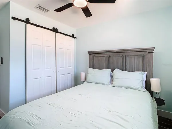 a bedroom with a large bed and a chandelier