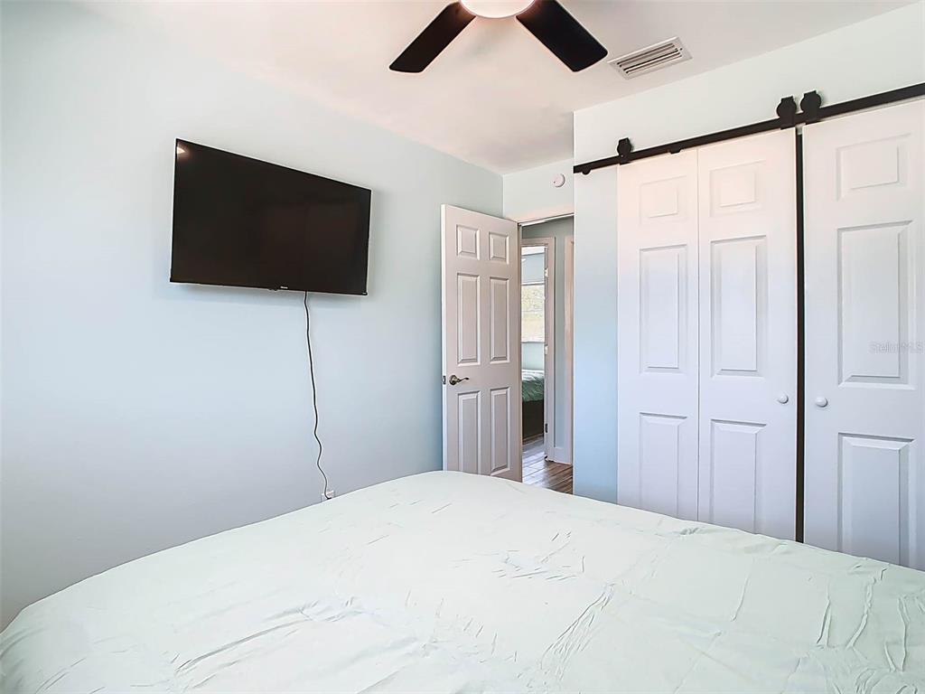 4984 Cedarbrook Lane Hernando Beach, FL 34607 - Photo 35 of 61 a bedroom with a large bed and a flat screen tv