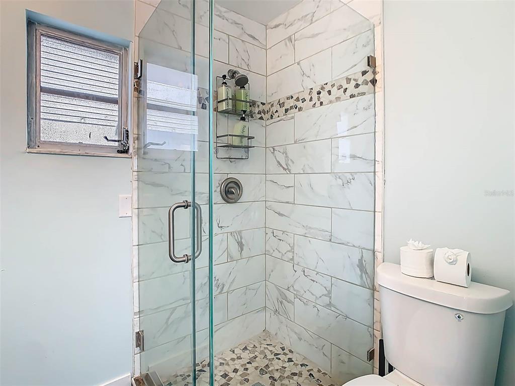4984 Cedarbrook Lane Hernando Beach, FL 34607 - Photo 43 of 61 a bathroom with a shower a toilet and a window