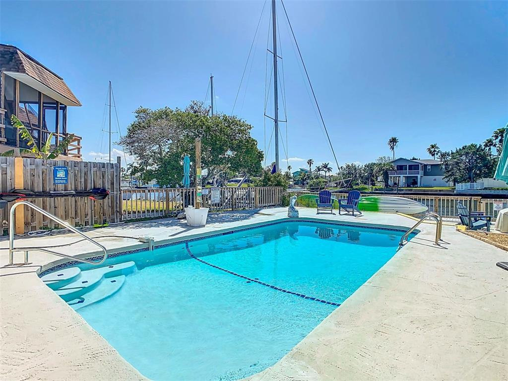 4984 Cedarbrook Lane Hernando Beach, FL 34607 - Photo 45 of 61 a view of a swimming pool with a lawn chairs