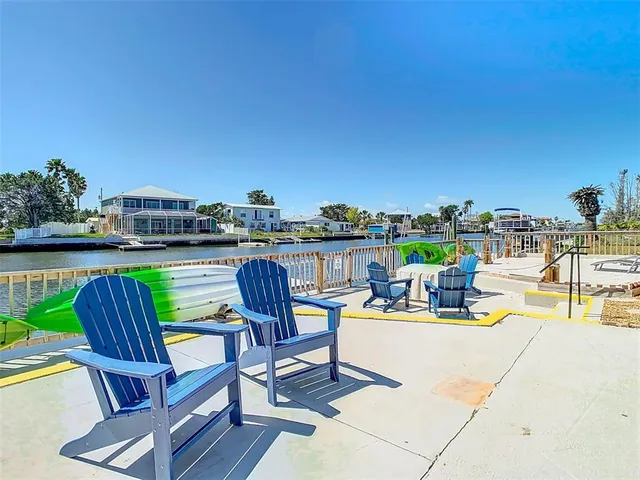 a view of a swimming pool with chairs and a yard