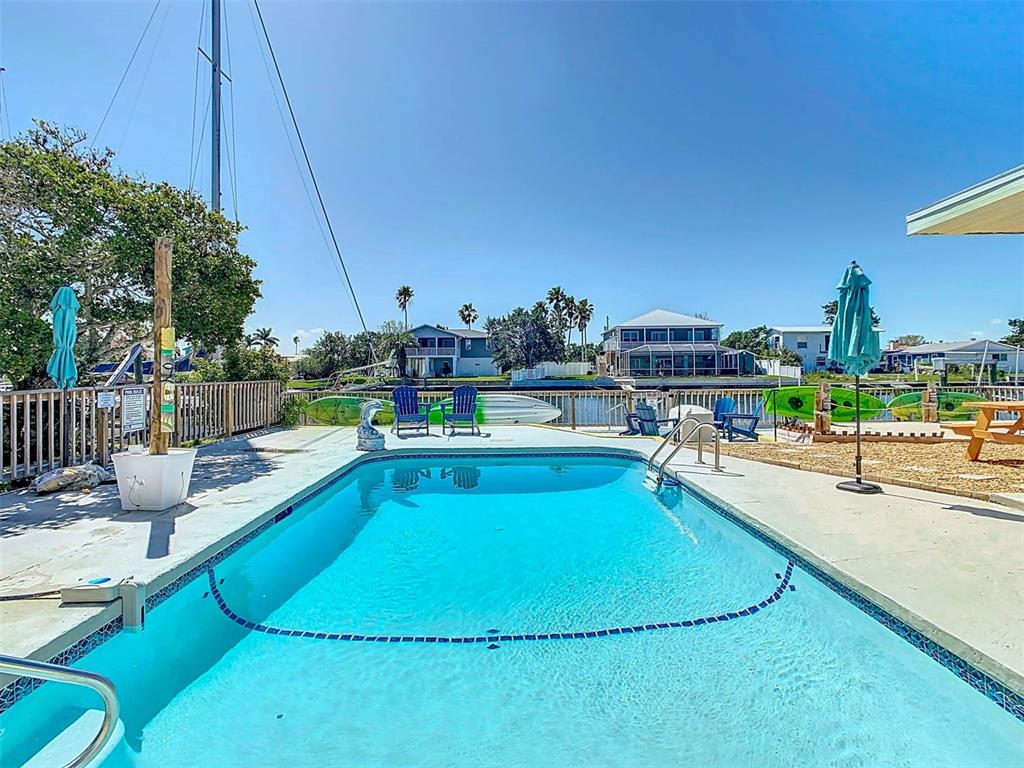 4984 Cedarbrook Lane Hernando Beach, FL 34607 - Photo 6 of 65 a view of a swimming pool with a lounge chairs