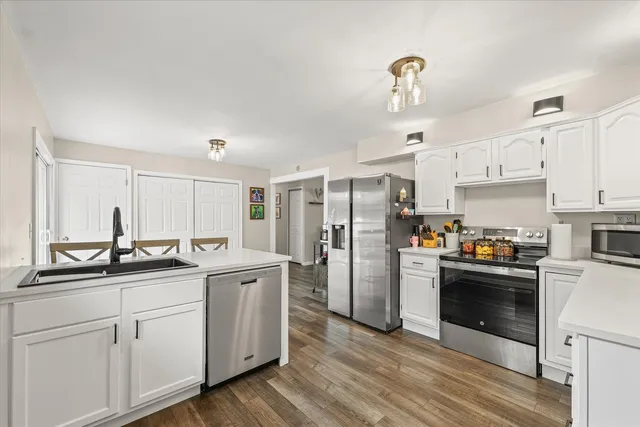 a kitchen with white cabinets and stainless steel appliances