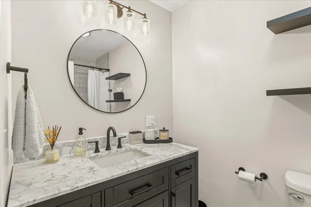 a bathroom with a granite countertop sink mirror and vanity