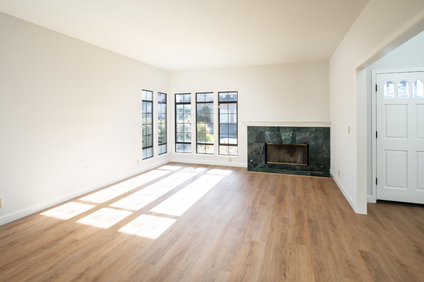 11 Fairway Place Half Moon Bay, CA 94019 - Photo 17 of 42 an empty room with wooden floor fireplace and windows