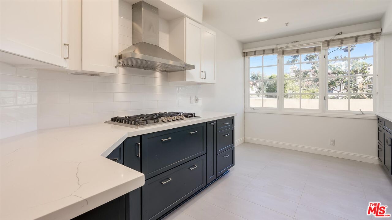 10555 Ashton Avenue, Unit 201 Los Angeles, CA 90024 - Photo 16 of 33 a kitchen with stainless steel appliances granite countertop a sink stove and white cabinets