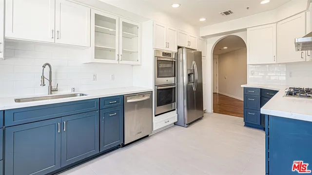 a kitchen with stainless steel appliances a sink cabinets and a refrigerator