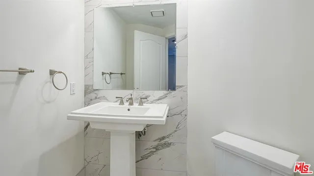 a bathroom with a sink a toilet and mirror