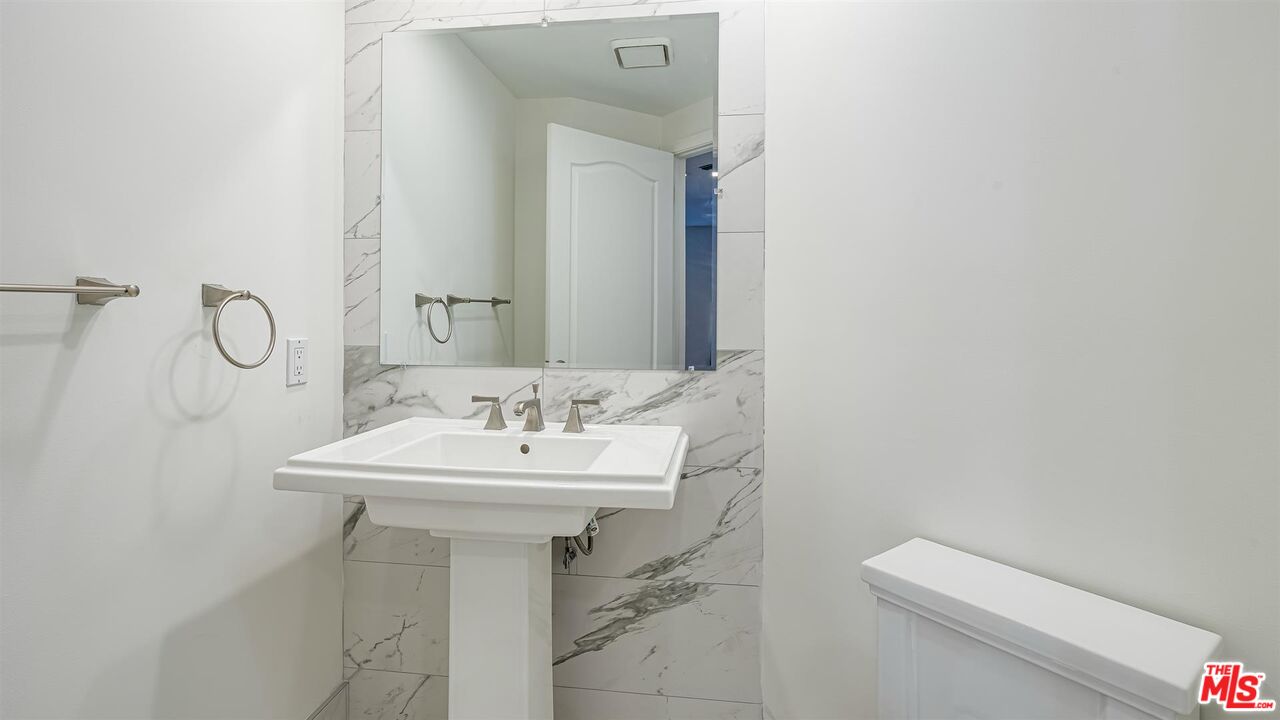 10555 Ashton Avenue, Unit 201 Los Angeles, CA 90024 - Photo 20 of 33 a bathroom with a sink a toilet and mirror