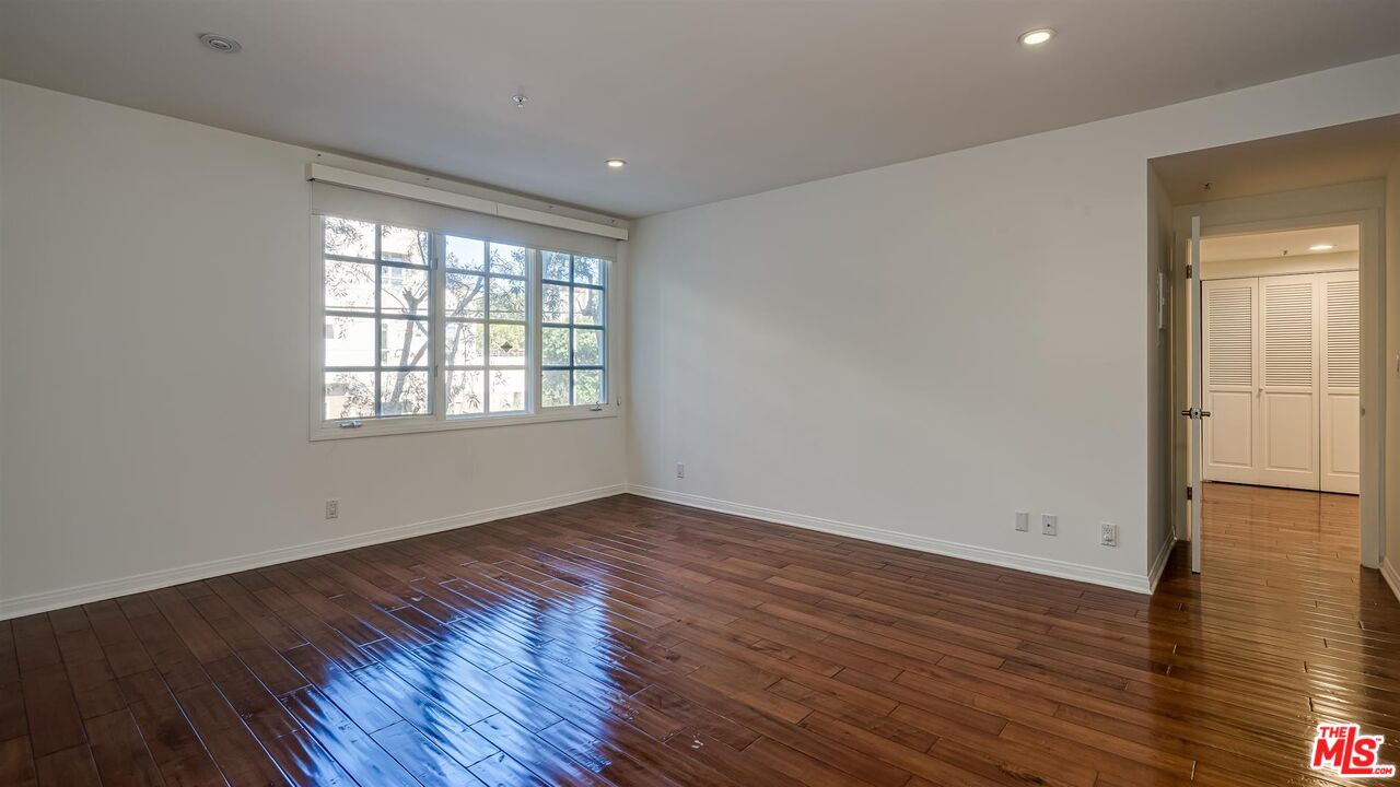 10555 Ashton Avenue, Unit 201 Los Angeles, CA 90024 - Photo 21 of 33 a view of an empty room with wooden floor and a window
