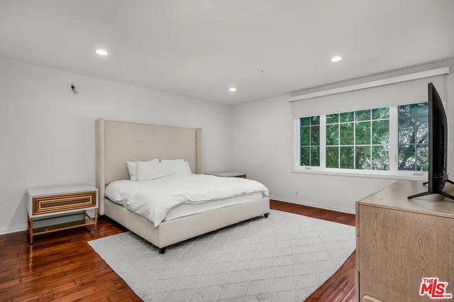 a bedroom with a bed and a large window