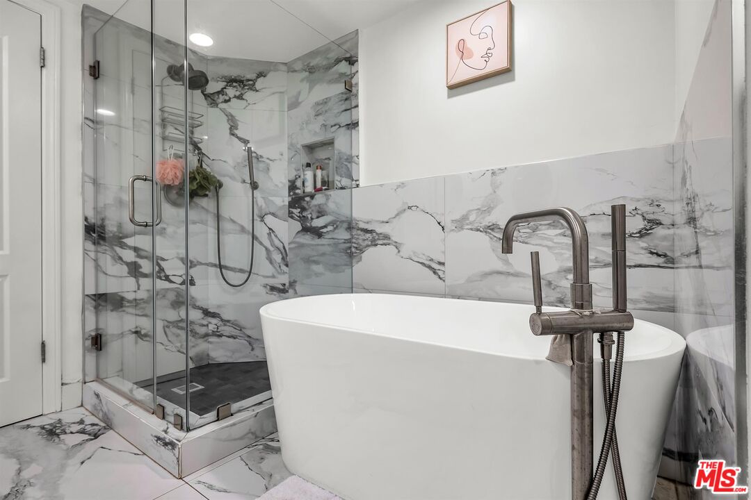 10555 Ashton Avenue, Unit 201 Los Angeles, CA 90024 - Photo 23 of 33 a bathroom with a sink a mirror and shower
