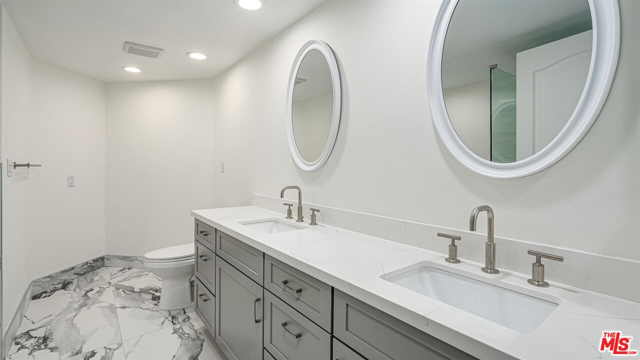 10555 Ashton Avenue, Unit 201 Los Angeles, CA 90024 - Photo 26 of 33 a bathroom with a sink and a mirror