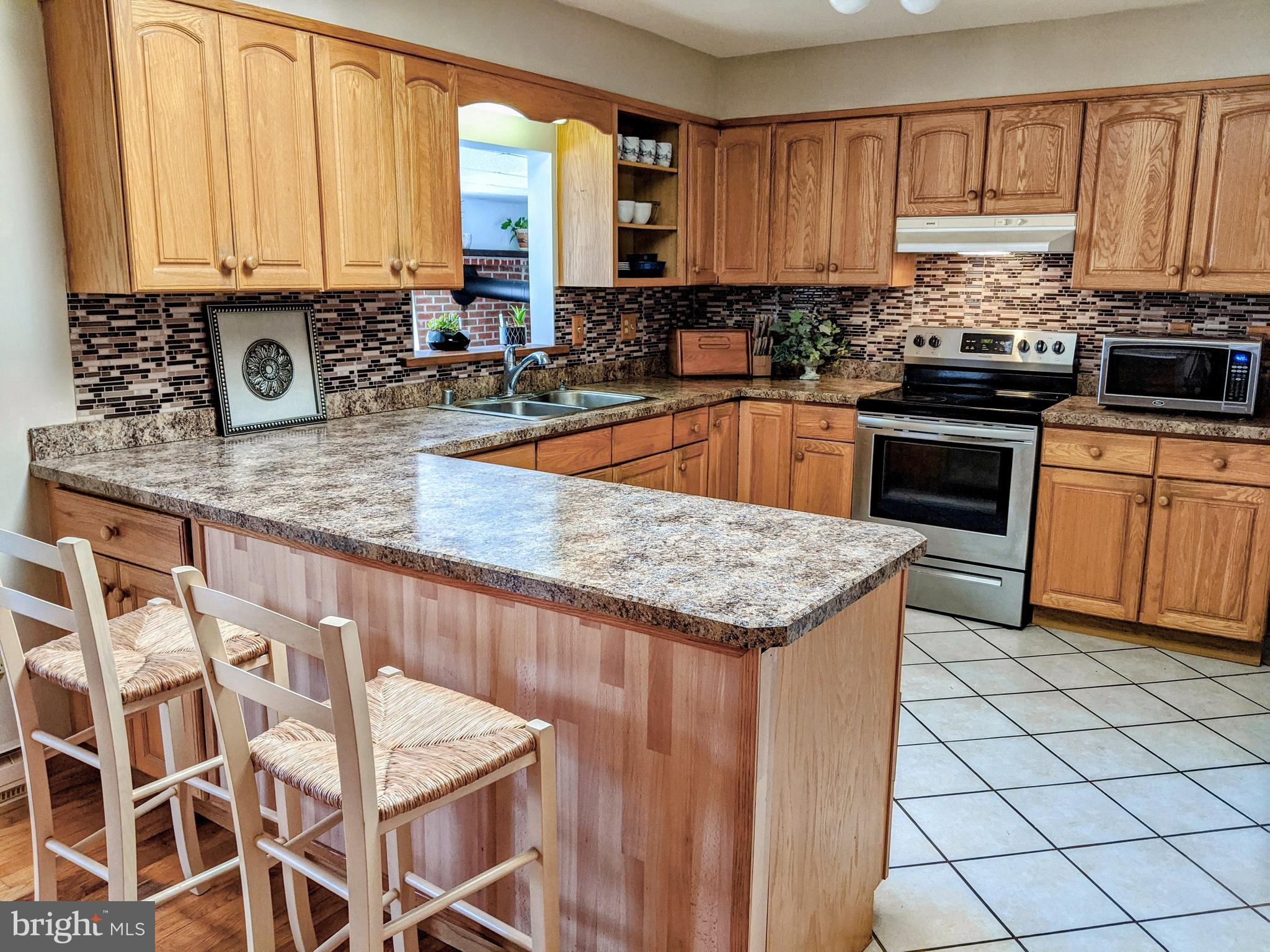 1342 Calvert Road Chester, MD 21619 - Photo 16 of 29 a kitchen with stainless steel appliances granite countertop a stove a sink a oven a dining table and chairs