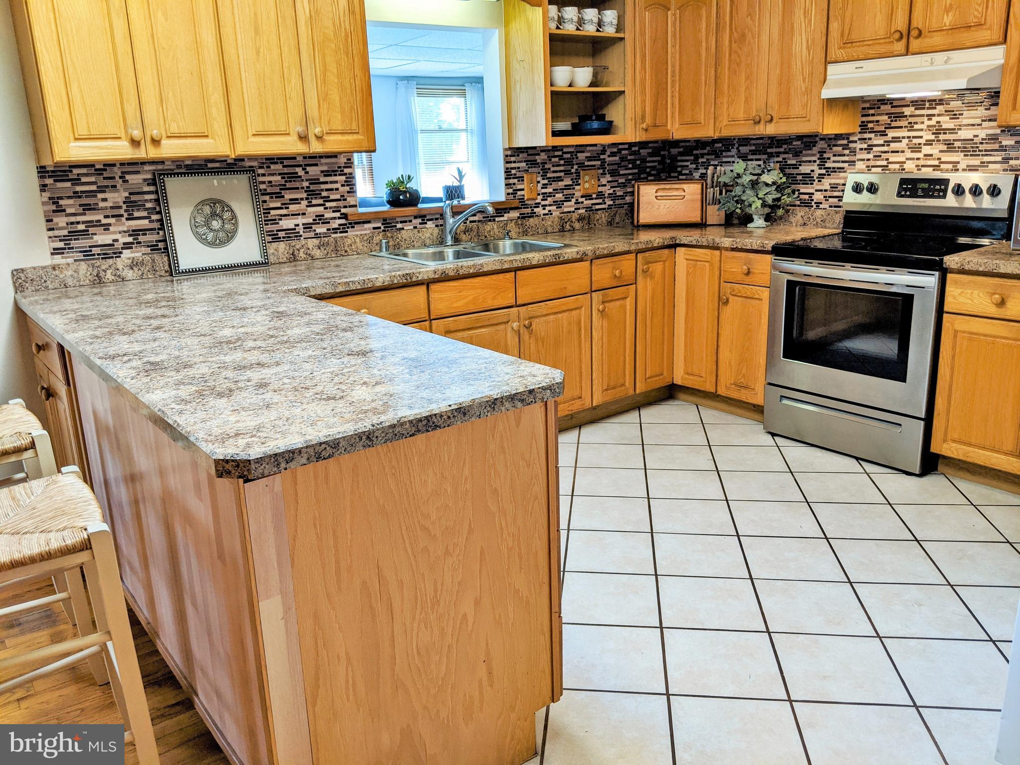 1342 Calvert Road Chester, MD 21619 - Photo 17 of 29 a kitchen with stainless steel appliances granite countertop a sink stove and cabinets