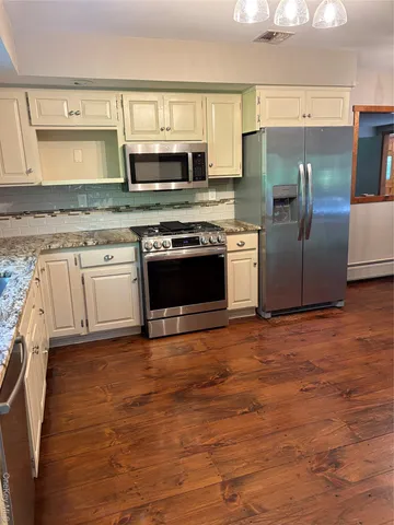 a kitchen with stainless steel appliances granite countertop a refrigerator and a stove top oven