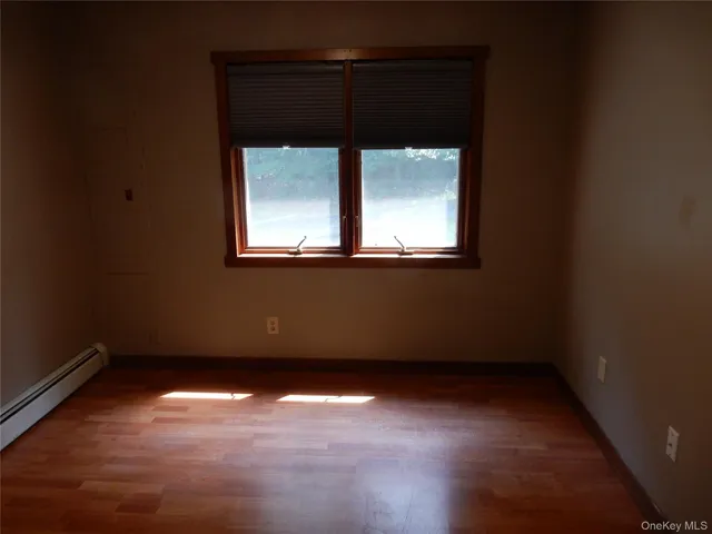 a view of a small space with wooden floor and a window