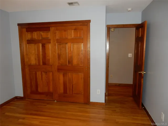 an empty room with wooden floor and closet