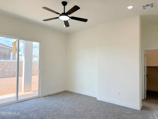 an empty room with windows and fan