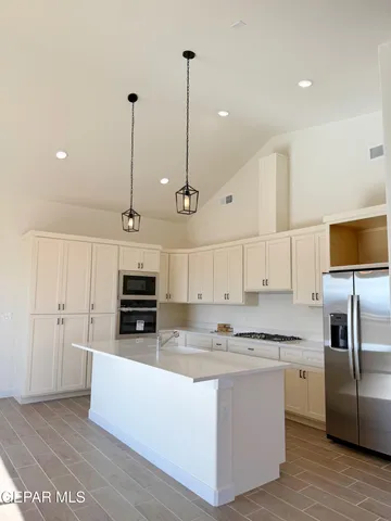 a kitchen with stainless steel appliances granite countertop a refrigerator a sink and a stove