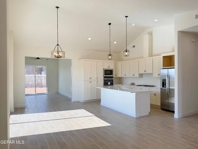 a kitchen with a sink a stove a refrigerator and white cabinets