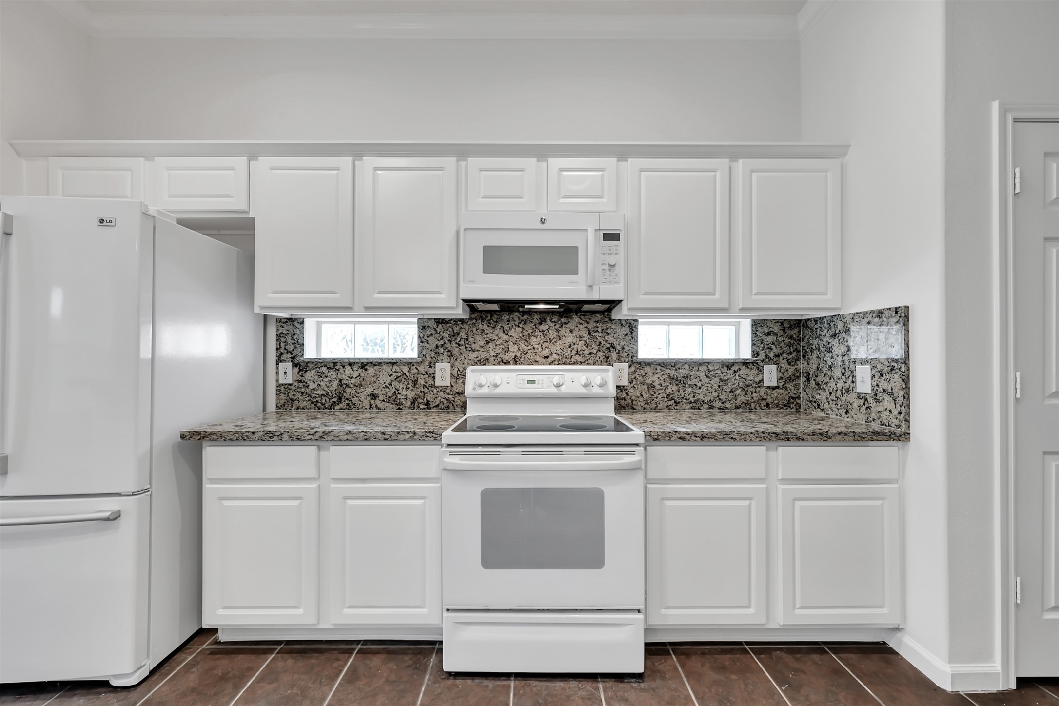 47 Presidio Road Montgomery, TX 77356 - Photo 8 of 35 a kitchen with white cabinets and white appliances
