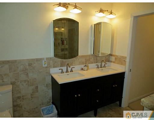 414 New Market Road Dunellen, NJ 08812 - Photo 17 of 25 a bathroom with a double vanity sink and a mirror
