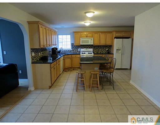 414 New Market Road Dunellen, NJ 08812 - Photo 6 of 25 a kitchen with stainless steel appliances a sink a counter top space and cabinets