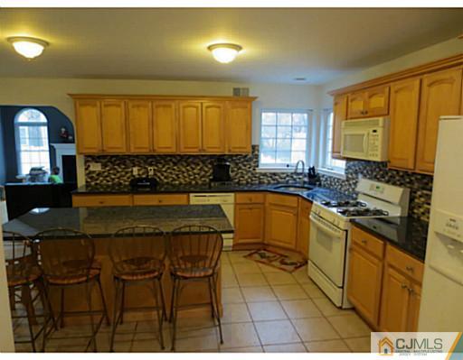 414 New Market Road Dunellen, NJ 08812 - Photo 9 of 25 a kitchen with a sink and wooden cabinets