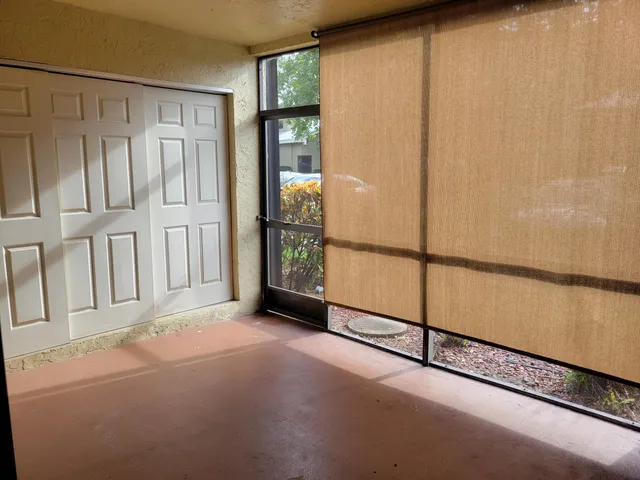 a view of a patio with a dining table and chairs with palm trees