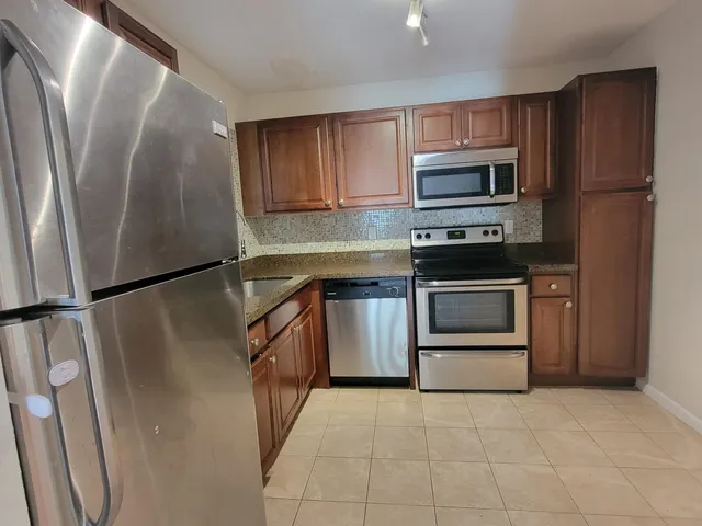 a kitchen with stainless steel appliances a refrigerator sink and microwave